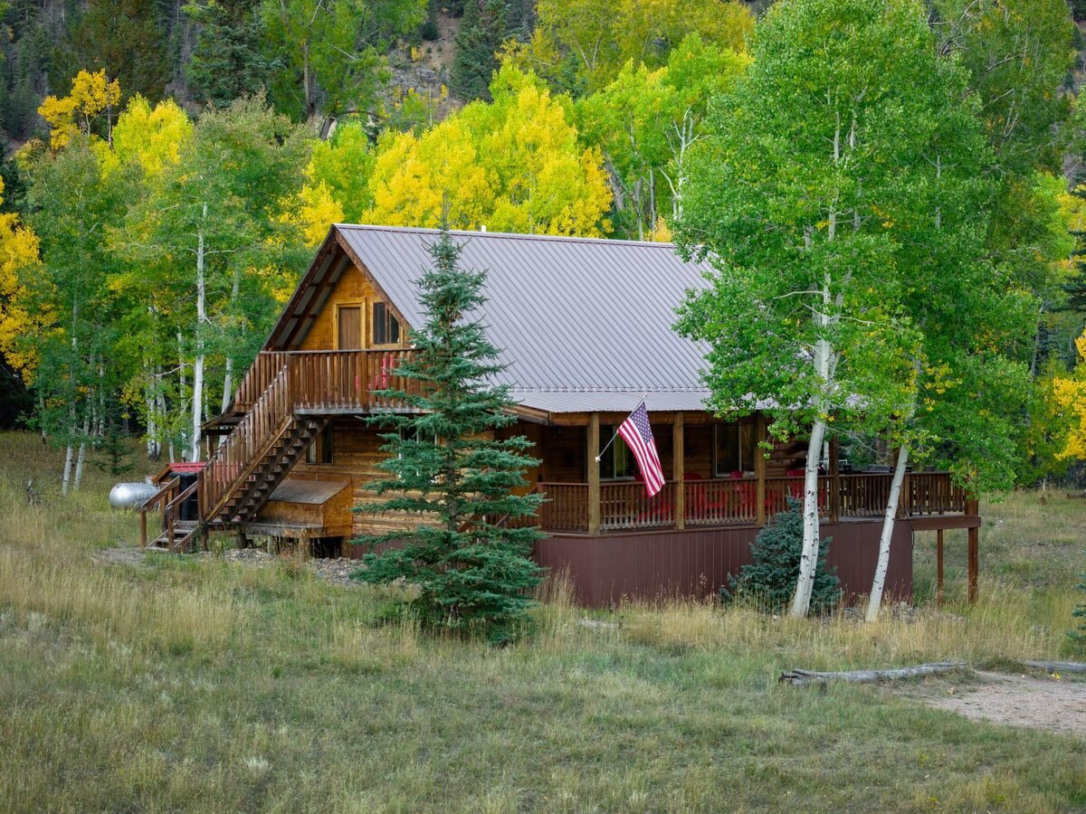 The Lost Elk Lodge, a log cabin among golden aspens in Jasper, Colorado