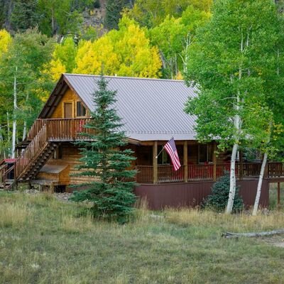 The Lost Elk Lodge, a hand built log cabin among golden aspens in Jasper, Colorado
