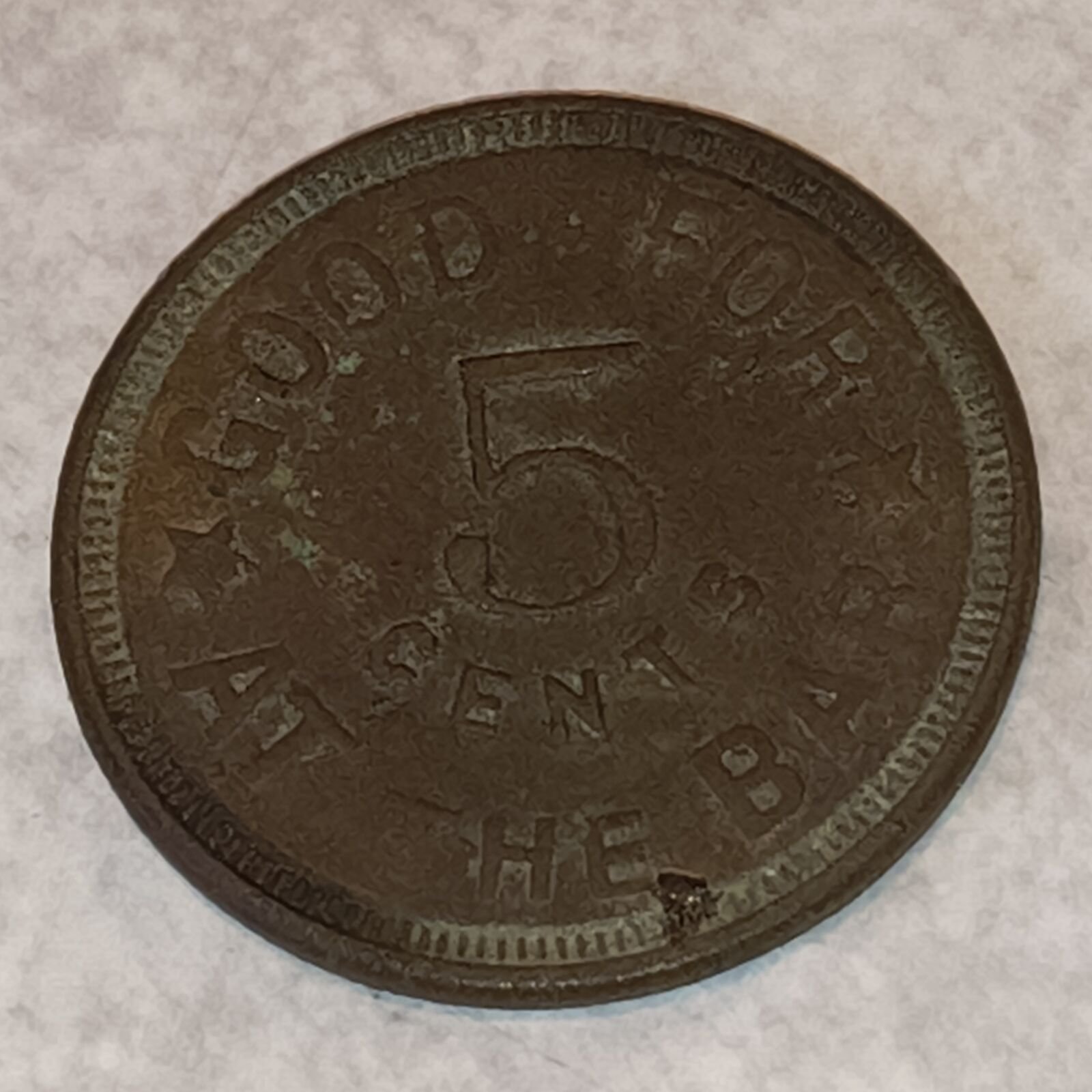 Worn brass token reading Good for 5 cents at the bar around a large numeral 5, with stars between the words